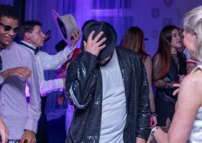 Guests dancing under disco lights at a 60th birthday party at Amersham & Chiltern Rugby Club