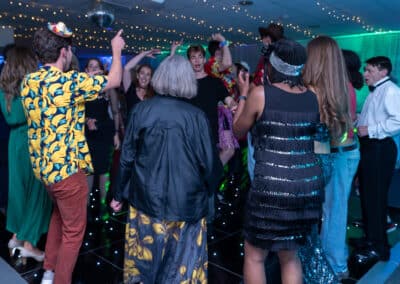 Guests in party outfits dancing on a light-up floor at Amersham & Chiltern Rugby Club