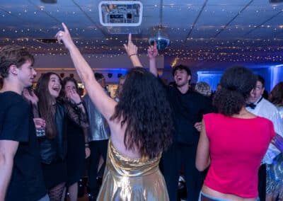 Guest laughing with arms raised at a 60th birthday disco at Amersham & Chiltern Rugby Club