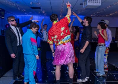 Guests in retro outfits dancing at a 60th birthday disco in Amersham