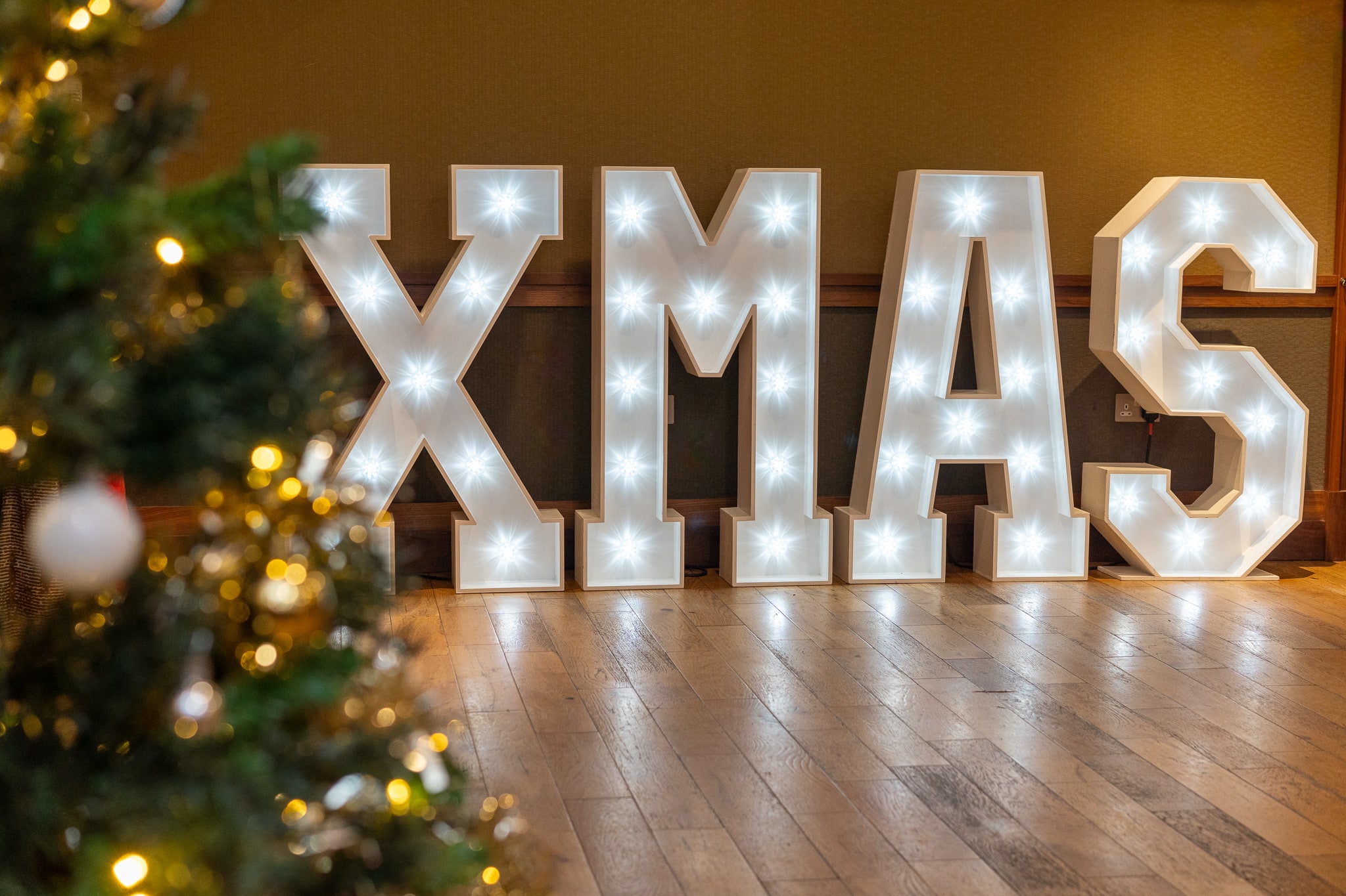 Christmas party DJ hire — light-up XMAS letters beside the tree