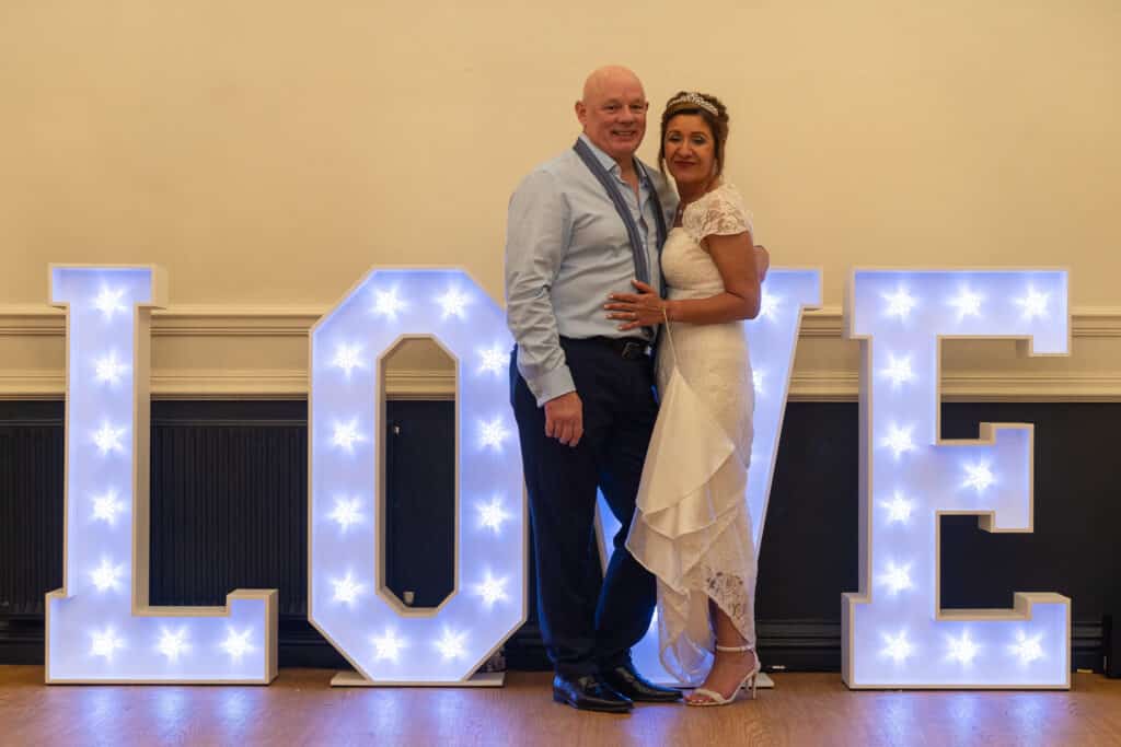 Sally and her new husband with our light-up LOVE letters at their wedding