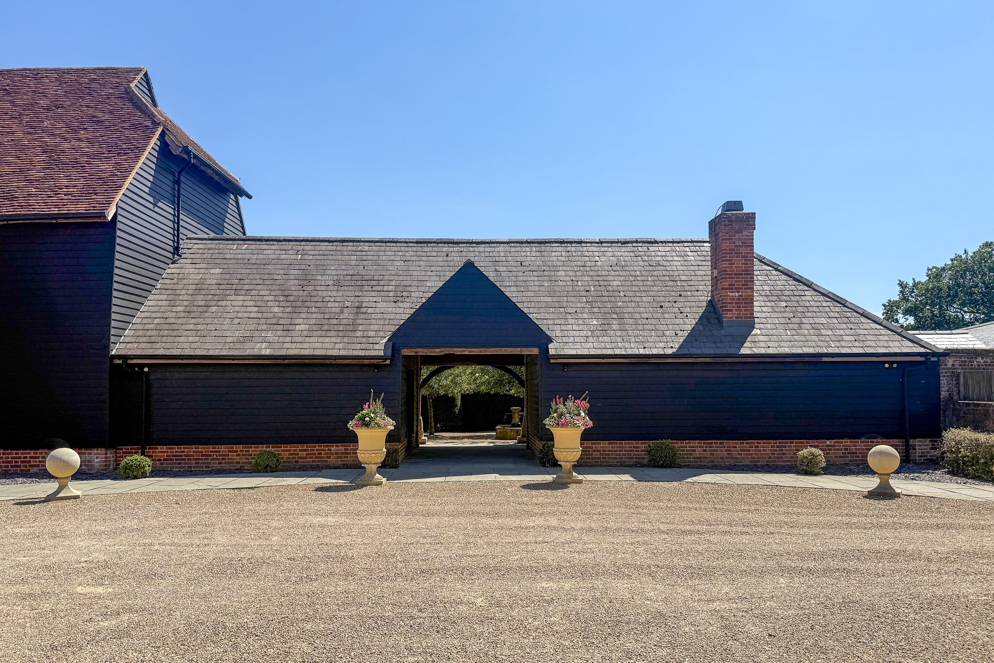 Barn entrance with flower urns at Micklefield Hall