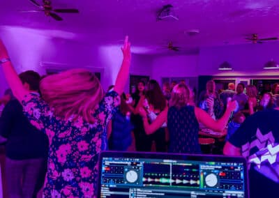 Packed dance floor under purple lights at a 50th birthday party at Berkhamsted Cricket Club