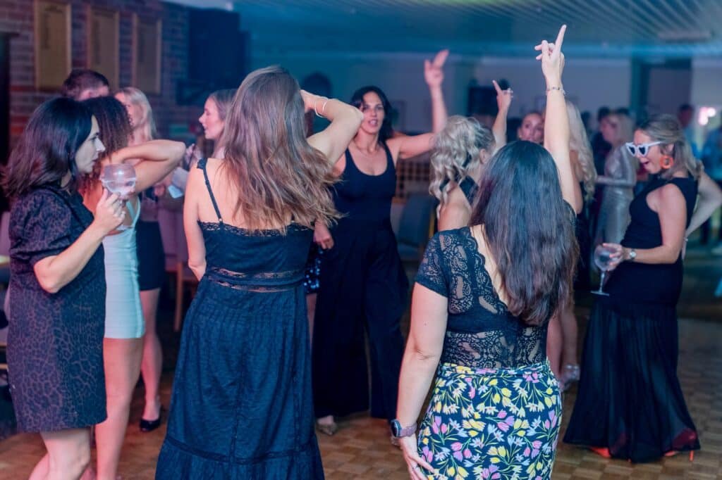 Guests of all ages dancing to 90s dance and pop at a 40th birthday party